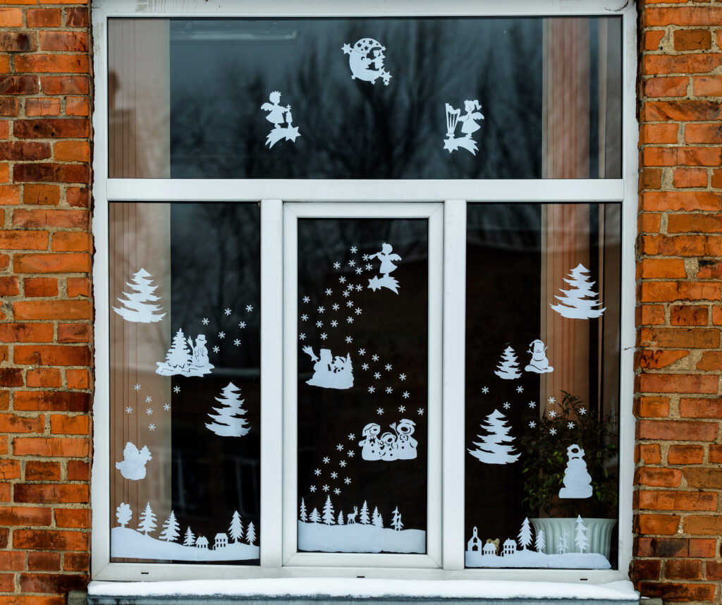 Homemade Christmas and New Year paper decoration on the window. handmade Christmas and New Year decorations on the window. New year and Christmas concept, handmade decorative paper on the window.